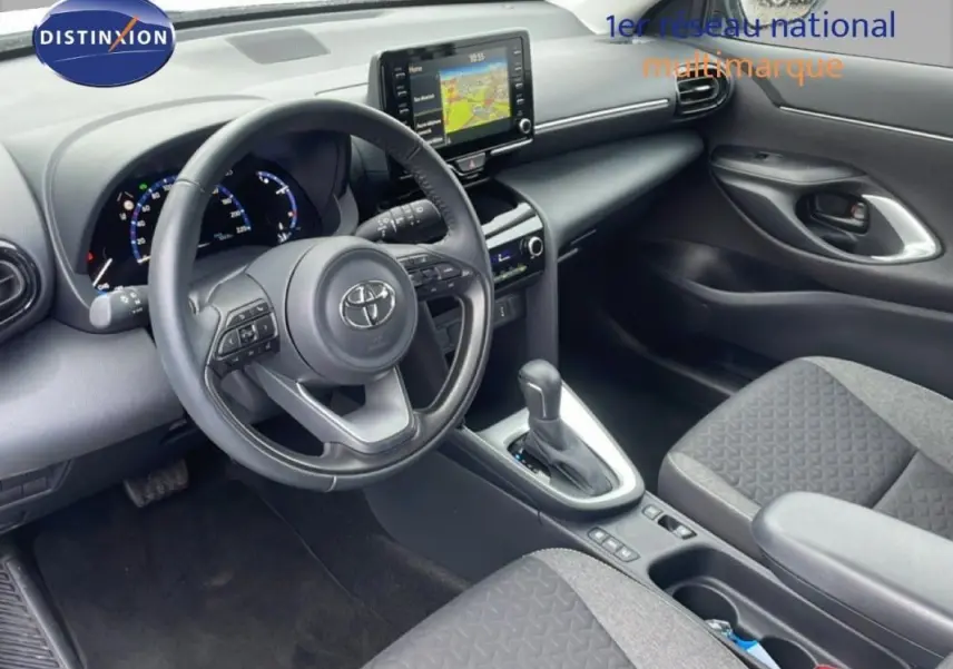 Vue intérieure côté conducteur de la Toyota Yaris Cross Hybrid 2024, volant cuir avec commandes et écran tactile GPS.
