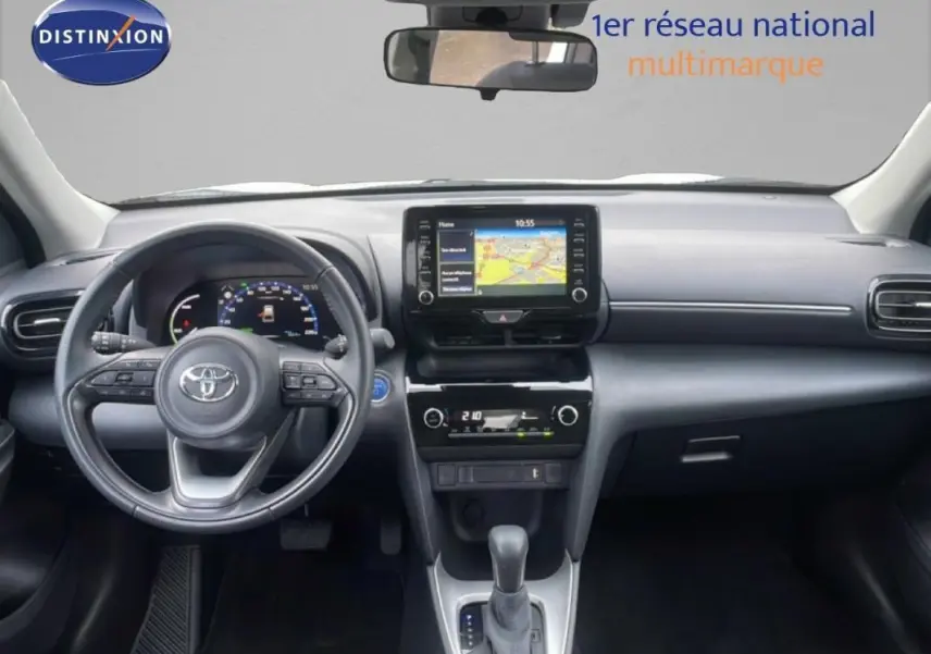 Vue intérieure frontale de la Toyota Yaris Cross Hybrid 117ch Business 2024, tableau de bord avec écran tactile et volant cuir.
