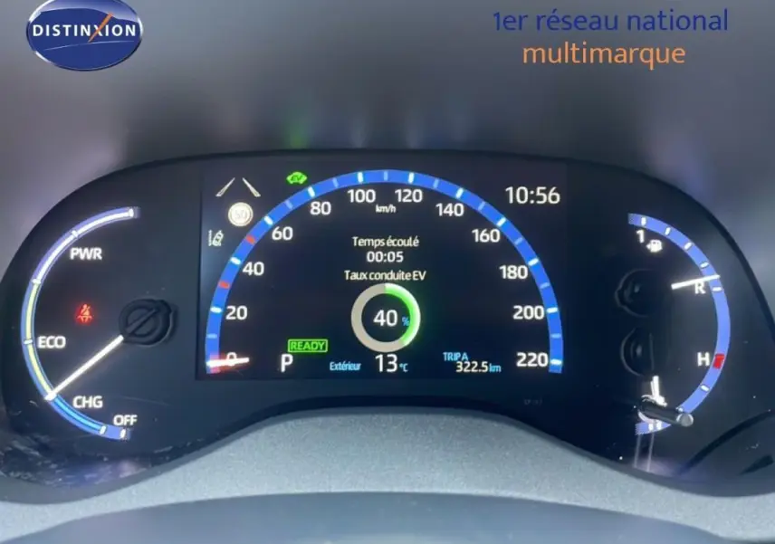 Tableau de bord numérique de Toyota Yaris Cross blanc 2024, affichage vitesse et indicateurs hybrides au centre.