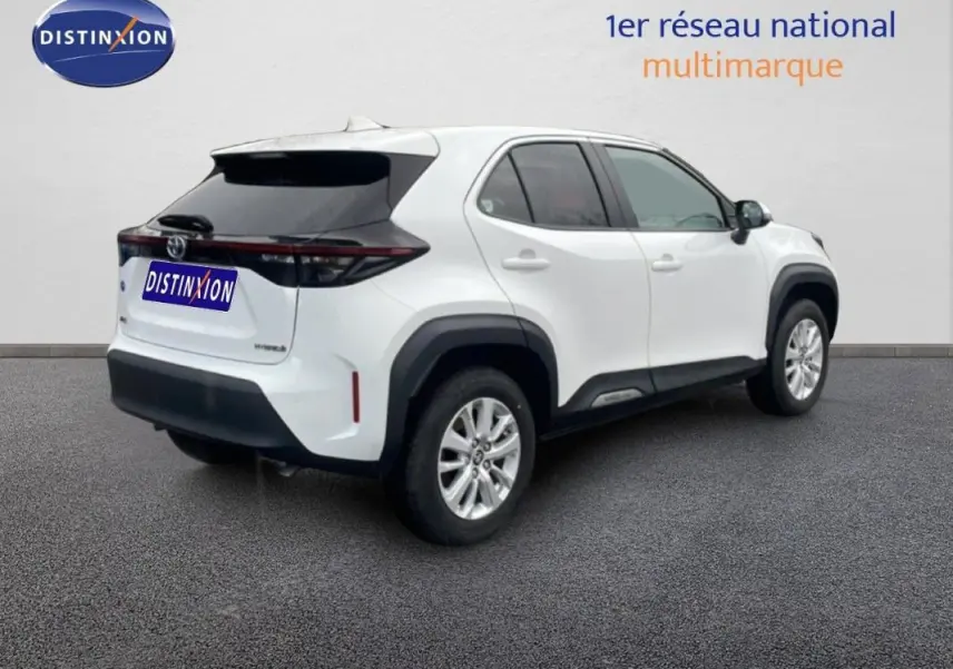 Vue 3/4 arrière droite d'une Toyota Yaris Cross Hybrid blanche avec jantes aluminium et toit noir contrasté.