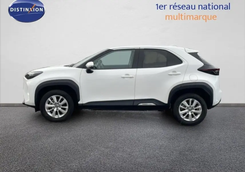 Profil droit de la Toyota Yaris Cross Hybrid blanche 2024 avec jantes aluminium 16 pouces et protections noires contrastées.