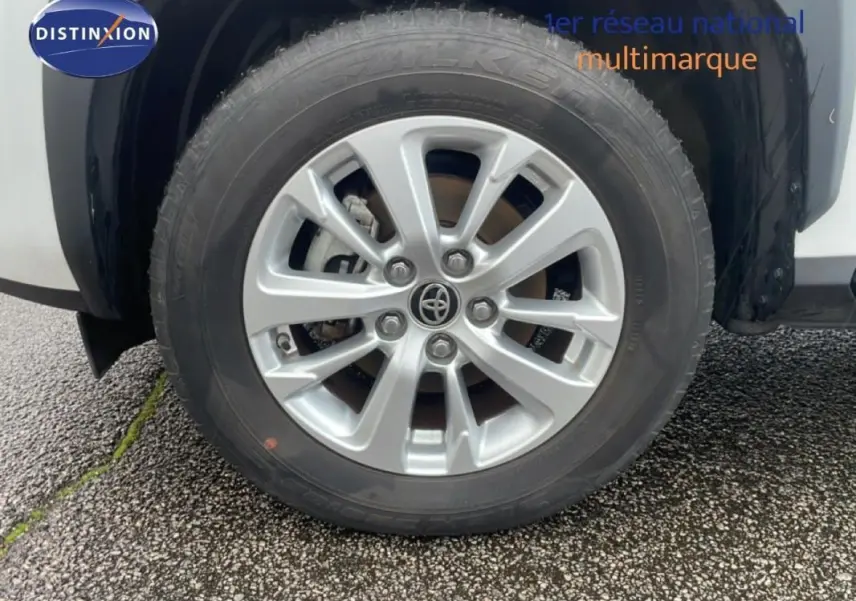 Gros plan sur la jante aluminium 16 pouces et le pneu du côté avant droit de la Toyota Yaris Cross blanche 2024.