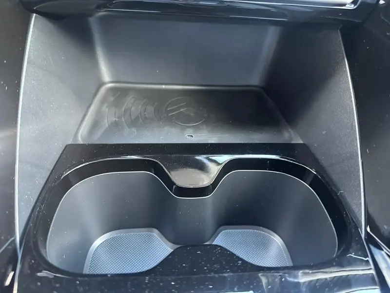 Gros plan intérieur sur les porte-gobelets noirs et le chargeur sans fil du Citroën C3 Aircross gris Mercury.