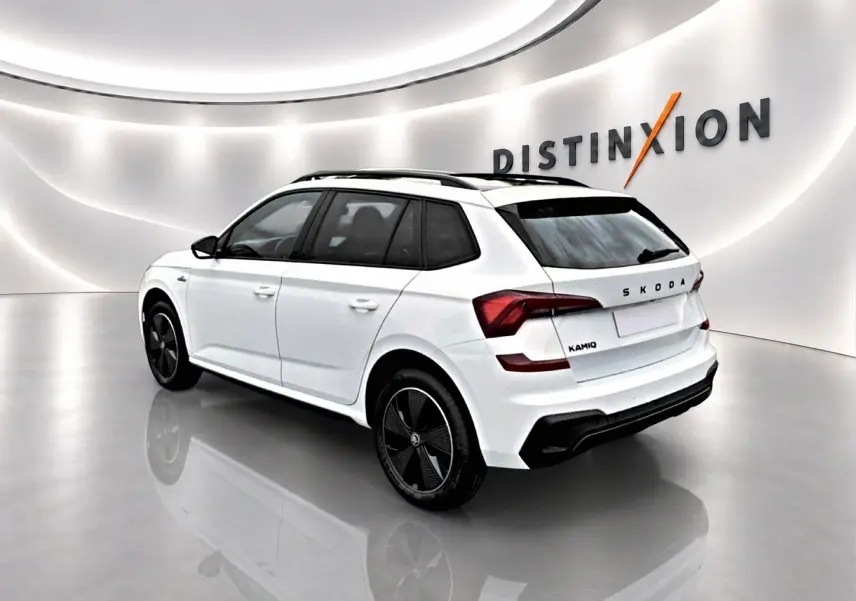 Vue 3/4 arrière droite d'un Skoda Kamiq blanc nacré avec jantes noires et toit panoramique en studio lumineux.