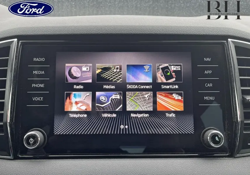Écran tactile central du tableau de bord du Skoda Karoq 2020 avec interface multimédia et navigation visible.
