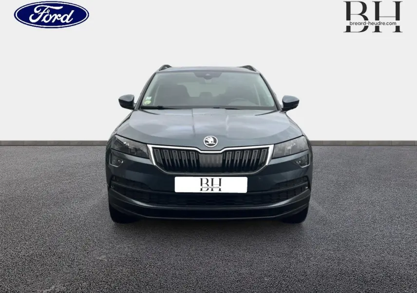 Vue avant d'un Skoda Karoq gris Business 2020 avec calandre chromée et phares LED distinctifs.