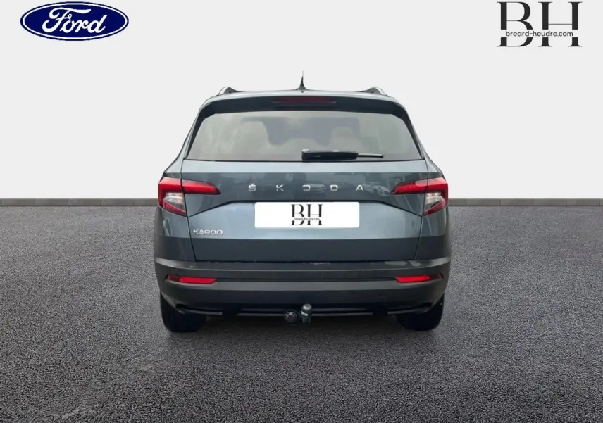 Vue arrière d'un Skoda Karoq gris Business 2020 avec attelage et feux arrière LED visibles.