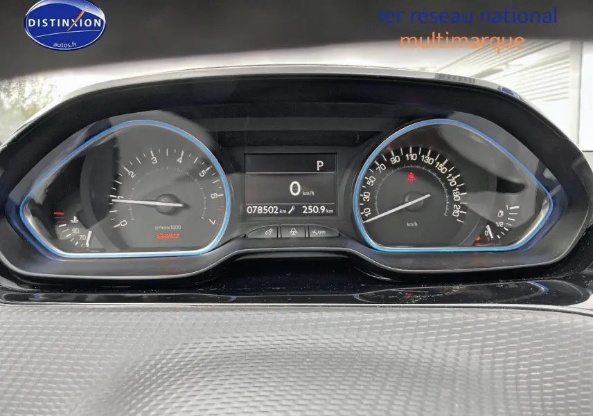 Tableau de bord du Peugeot 2008 essence blanc nacré, affichant compteur et vitesse à l'arrêt.