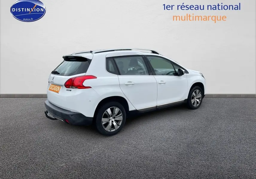 Peugeot 2008 blanc nacré en 3/4 arrière droit, SUV compact avec jantes alliage et barres de toit noires.
