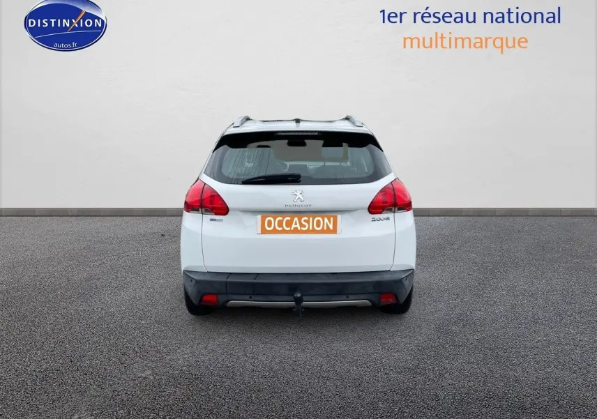 Vue arrière d'un Peugeot 2008 blanc nacré de 2015 avec attelage et feux arrière rouges bien visibles.