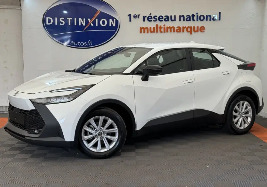 Toyota C-HR 1.8 Hybride blanc vu de profil côté gauche, avec jantes alliage et détails noirs contrastants.