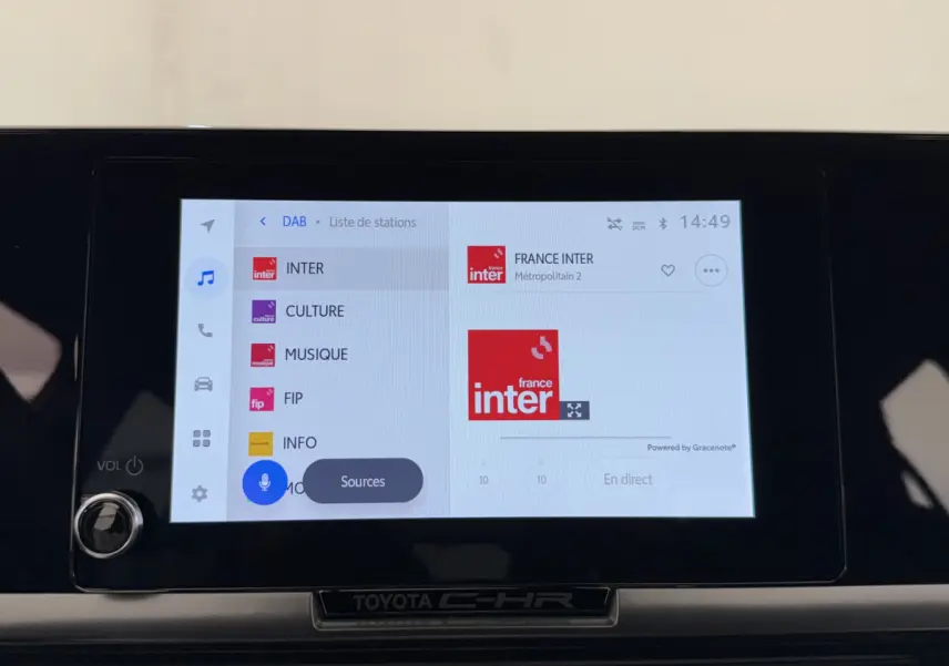 Écran tactile central du Toyota C-HR 1.8 Hybride blanc, affichant la radio France Inter en mode DAB.
