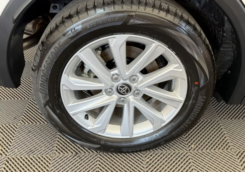 Gros plan sur la roue avant droite du Toyota C-HR blanc 2024 avec jante alliage et pneu Bridgestone.