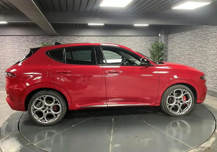 Profil droit de l'Alfa Romeo Tonale 2024 rouge avec jantes alliage 20 pouces et rétroviseurs noirs brillants.