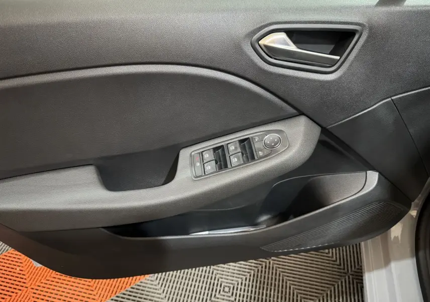 Panneau de porte avant gauche de Renault Clio gris clair 2025 avec commandes électriques des vitres et rétroviseurs.