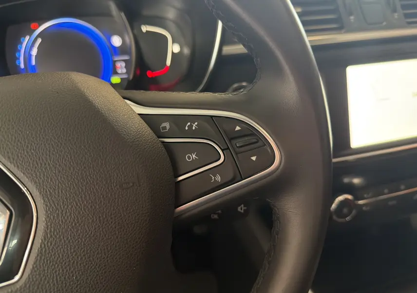 Gros plan sur le volant noir du Renault Kadjar 2016 avec commandes multifonctions et tableau de bord éclairé en bleu.