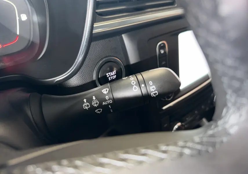 Gros plan sur la commande d’essuie-glace du Renault Kadjar gris, avec bouton start/stop et tableau de bord partiellement visible.