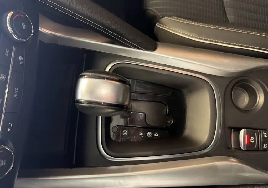 Vue rapprochée du levier de vitesses automatique gris et noir du Renault Kadjar 2016, avec frein à main électronique.