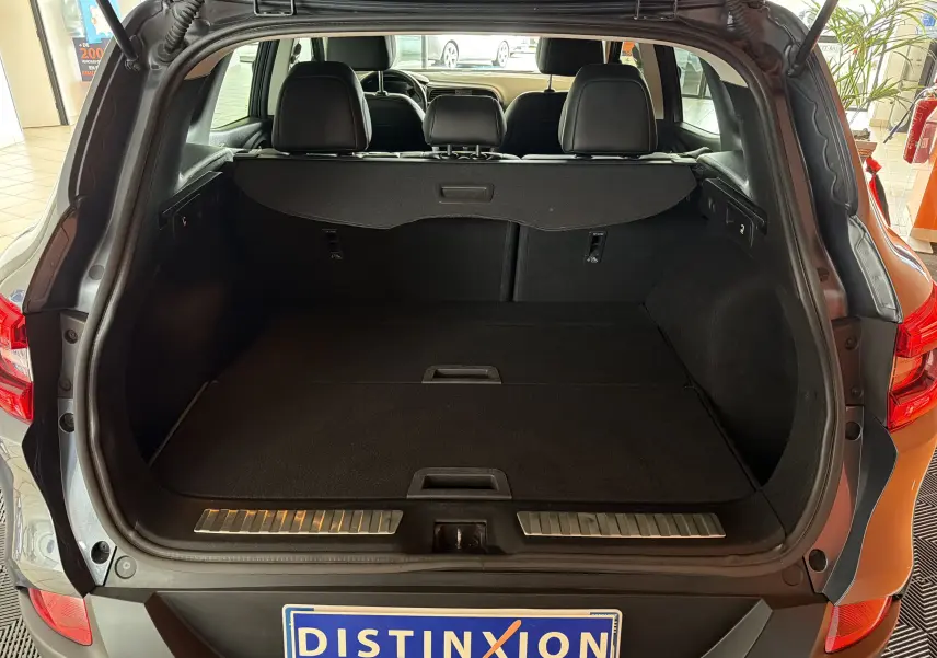 Coffre ouvert vu de l'arrière d'un Renault Kadjar gris 2016, montrant l'espace de chargement et les sièges arrière.