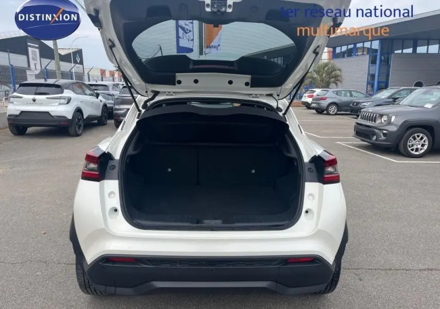 Vue arrière d'un Nissan Juke blanc 2024 avec coffre ouvert, mettant en valeur son espace de chargement.
