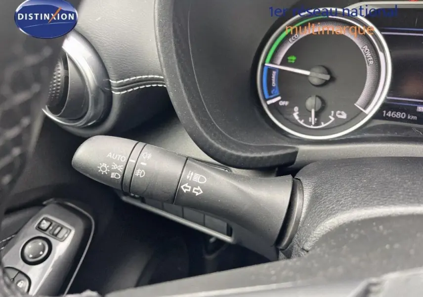 Gros plan sur la commande des feux et clignotants à gauche du volant dans un Nissan Juke blanc 2024 hybride.