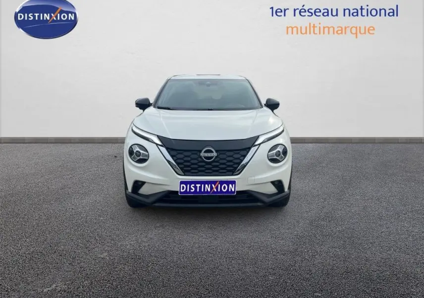 Vue de face du Nissan Juke blanc 2024 avec calandre noire et phares ronds distinctifs sur fond neutre.