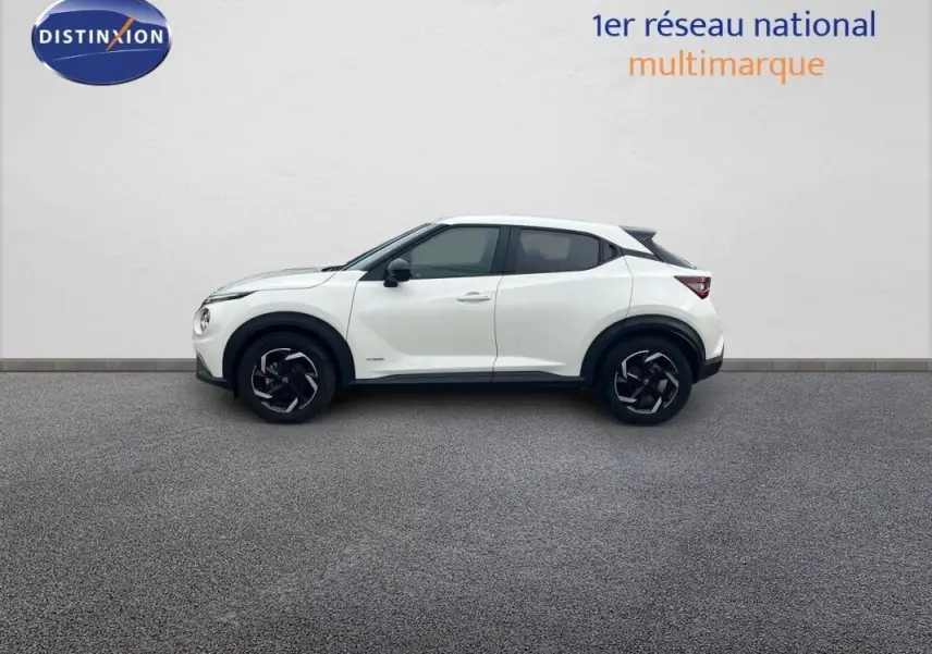 Profil droit d'un Nissan Juke blanc 2024 avec jantes aluminium et rétroviseurs noirs contrastants.