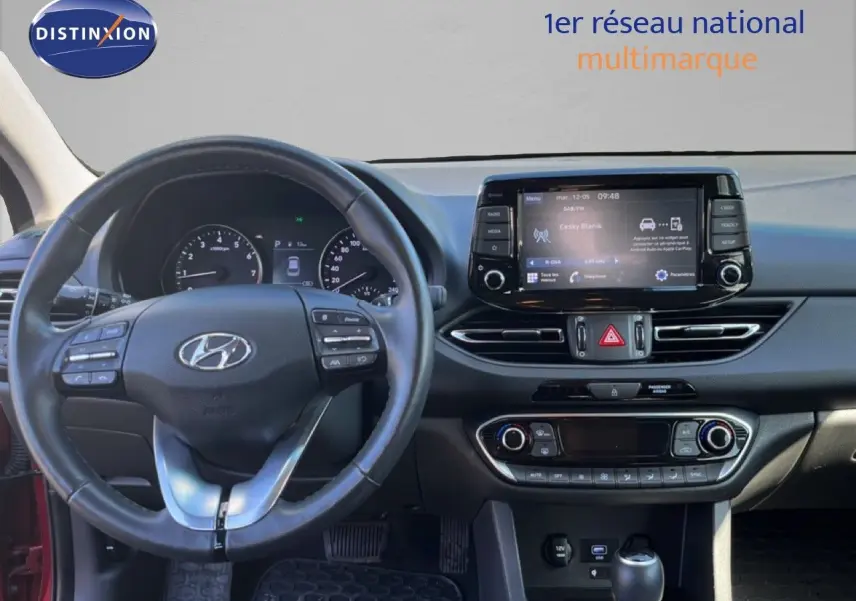 Vue intérieure du tableau de bord de la Hyundai i30 SW 2023, avec volant multifonction et écran tactile central.