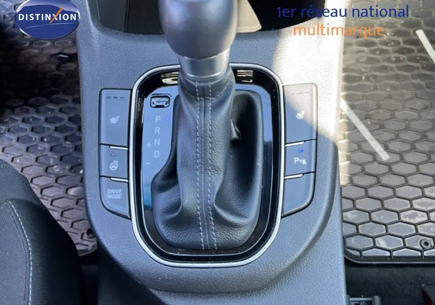 Gros plan sur la console centrale de la Hyundai i30 SW 2023 avec levier de vitesses automatique et boutons de sièges chauffants.