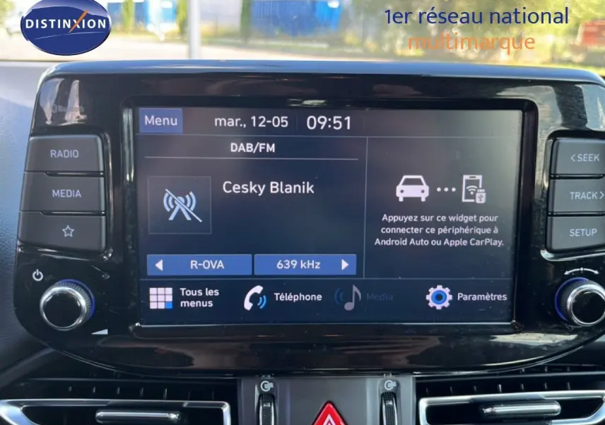 Écran tactile central de la Hyundai i30 SW 2023 affichant la radio DAB/FM avec commandes autour en intérieur noir.