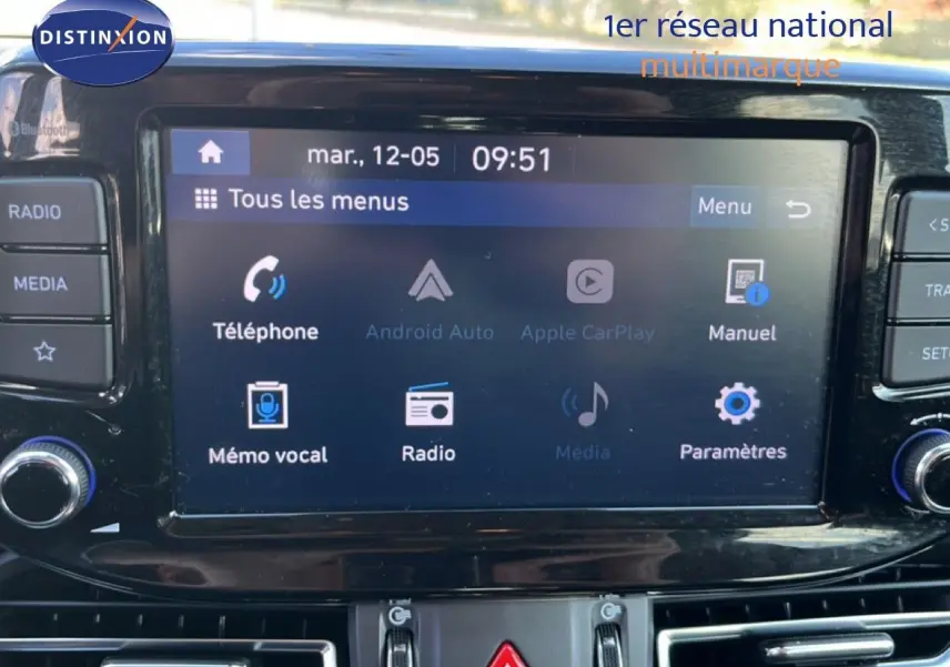 Écran tactile central de la Hyundai i30 SW 2023 affichant les menus téléphone, radio et paramètres, avec commandes autour.