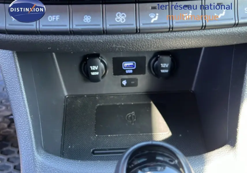 Gros plan sur la console centrale de la Hyundai i30 SW 2023, montrant prises 12V, port USB et commandes climatisation.