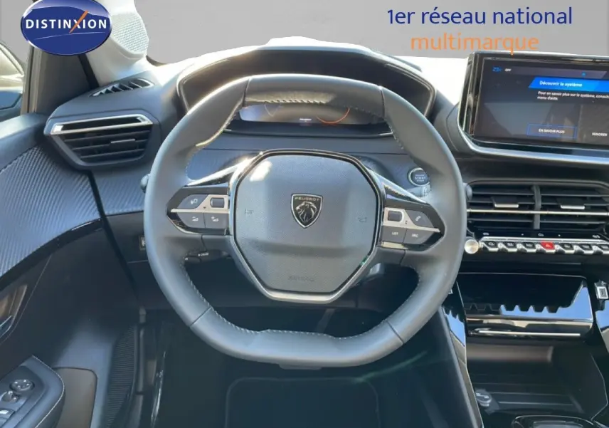 Vue intérieure centrée sur le volant noir de la Peugeot 208 Hybrid 110ch, avec tableau de bord et écran tactile visibles.