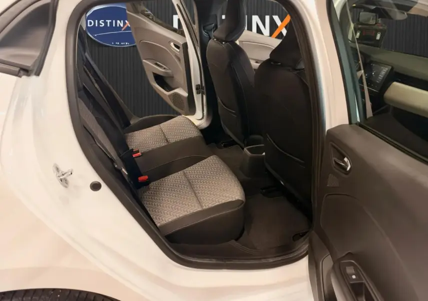 Vue intérieure côté gauche arrière de la Renault Clio V blanche, montrant les sièges arrière en tissu gris et noir.