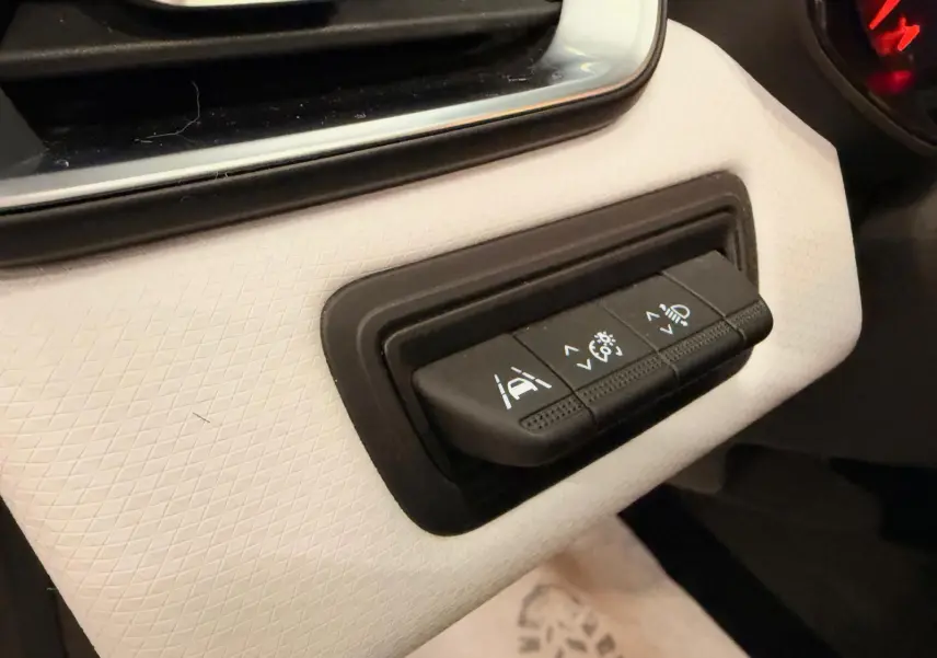Gros plan sur les commandes d’aide à la conduite sur tableau de bord blanc de la Renault Clio V blanche, version GPL/essence.