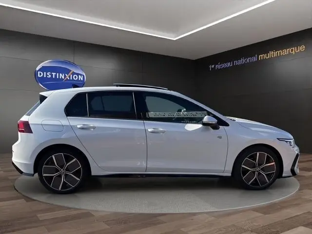 Vue de profil droit d'une Volkswagen Golf blanche 2.0 TDI R-Line avec toit panoramique et jantes distinctives.