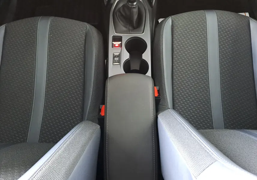 Vue plongeante sur les sièges avant noirs et la console centrale avec levier de vitesse manuelle d'une Peugeot 2008 2020.