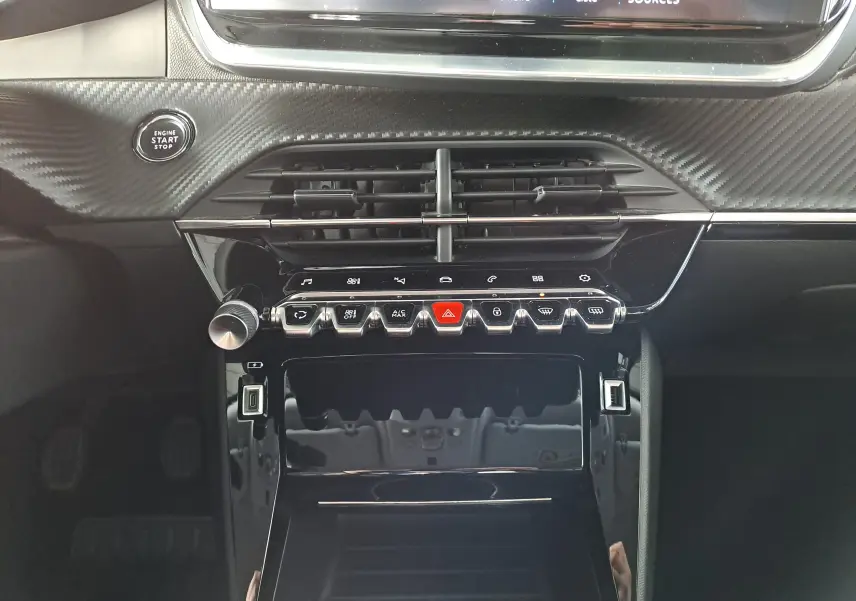 Tableau de bord intérieur du Peugeot 2008 1.2 PureTech 100 Allure 2020, avec console centrale noire brillante et bouton start/stop.