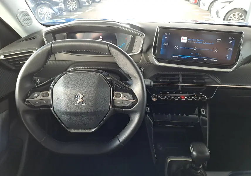 Vue intérieure centrée sur le volant et le tableau de bord numérique du Peugeot 2008 bleu Vertigo, avec écran tactile et commandes intégrées.