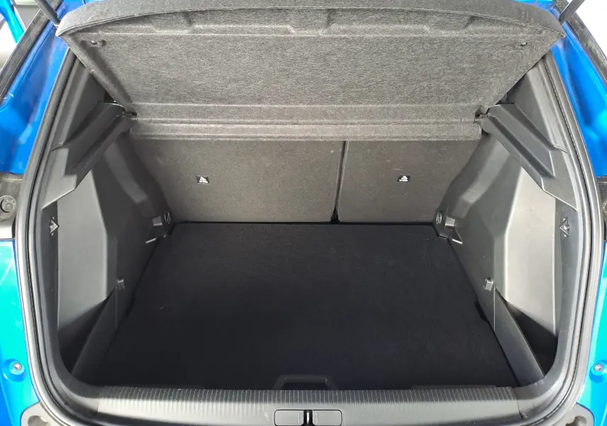 Coffre ouvert vu de l'arrière d'un Peugeot 2008 bleu Vertigo, montrant un espace de chargement propre et spacieux.