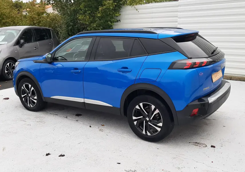 Peugeot 2008 bleu Vertigo vue de profil côté gauche, avec toit noir et jantes alliage noires.