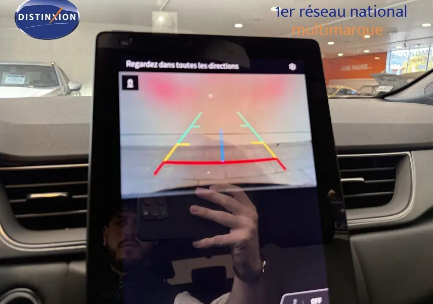 Écran tactile intérieur affichant la caméra de recul d'un Renault Captur gris Cassiopée métal avec toit gris, vue avant.