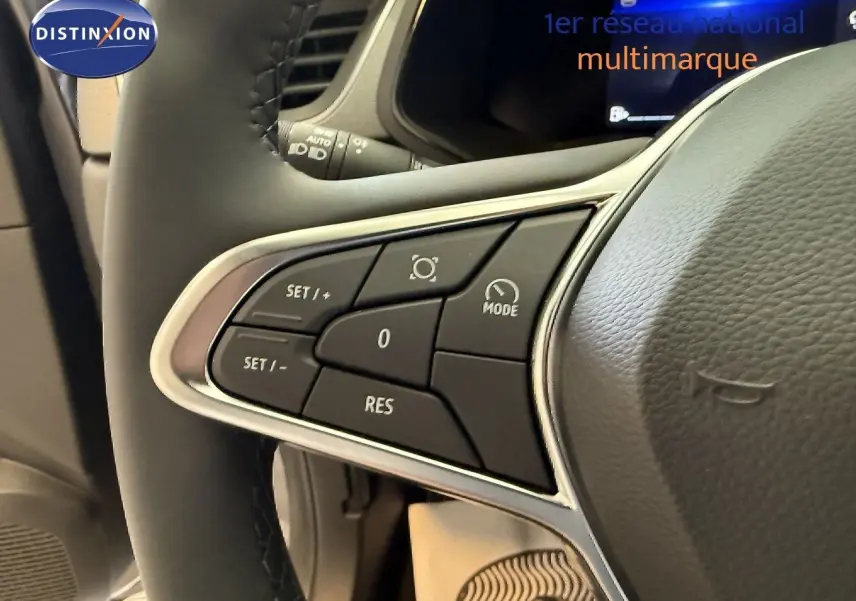 Gros plan sur les commandes du volant du Renault Captur gris cassiopée, mettant en valeur les boutons de régulateur de vitesse.