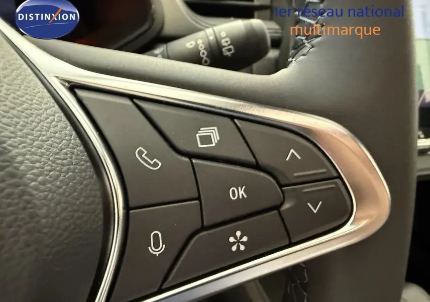 Gros plan sur les commandes multifonctions noires du volant du Renault Captur gris Cassiopée Métal 2025.