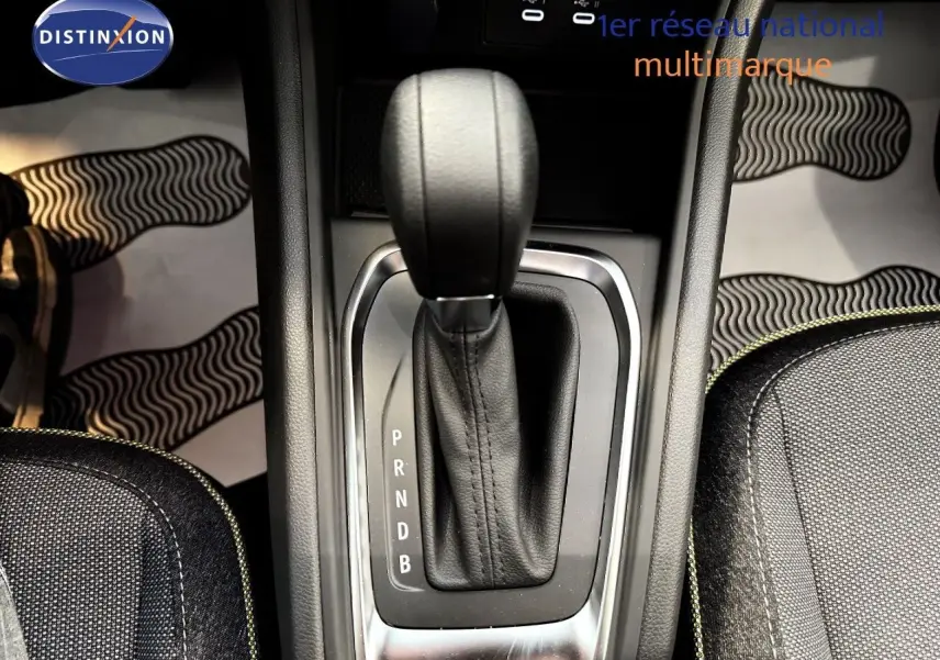 Le levier de vitesses automatique du Renault Captur 2025 en gros plan, entouré de sièges en tissu gris.