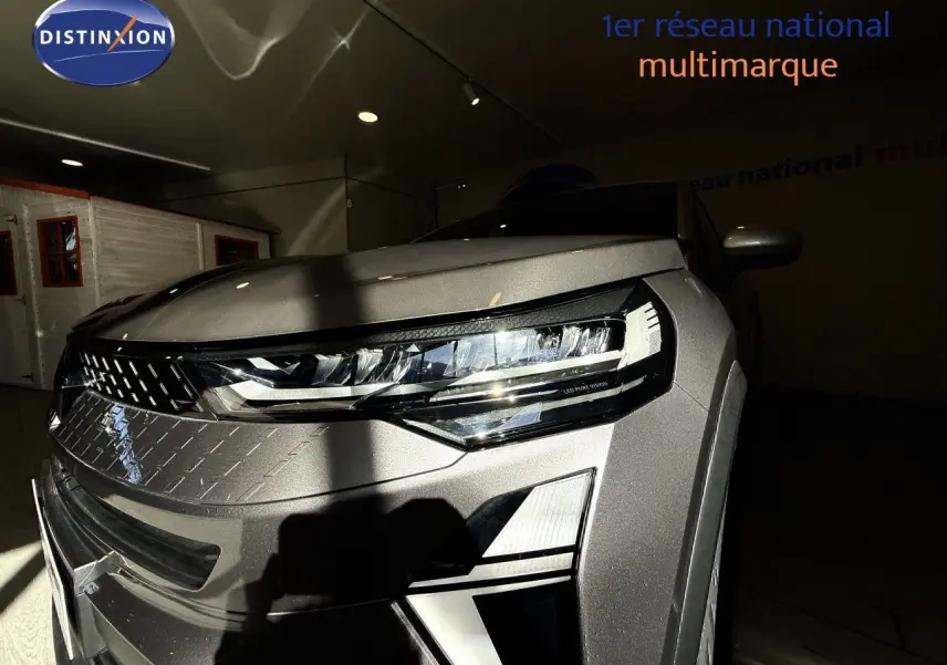 Vue avant droite du Renault Captur 2025 gris Cassiopée métal avec phares LED et calandre distinctive.