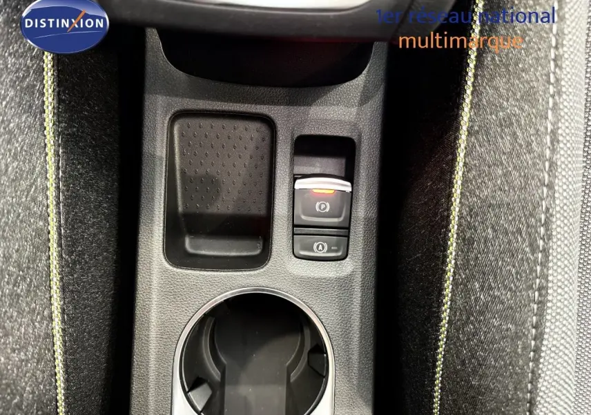 Gros plan sur la console centrale du Renault Captur 2025, montrant porte-gobelet et commandes électroniques, avec surpiqûres jaunes.