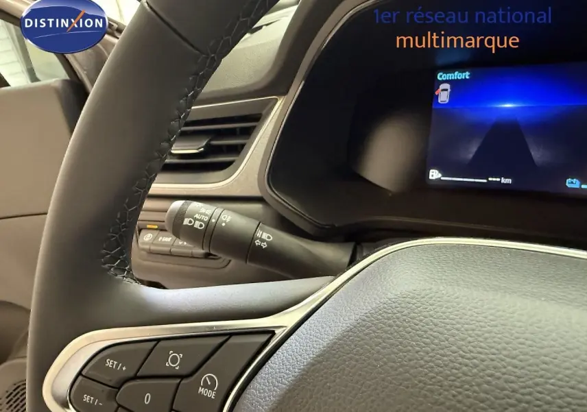 Vue rapprochée du volant et du combiné d'instruments numérique du Renault Captur 2025, avec commandes au volant visibles.