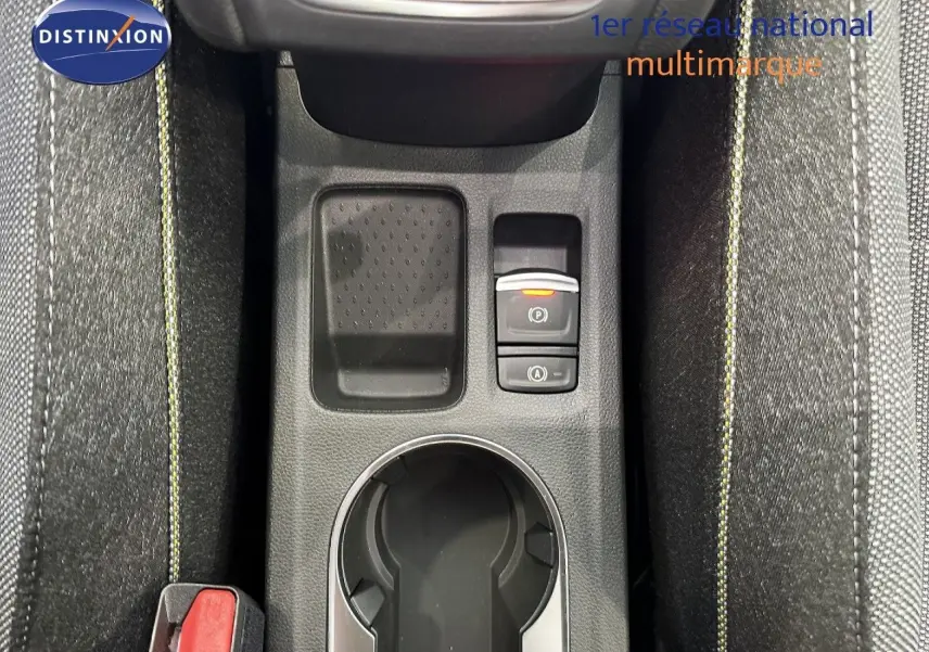 Vue plongeante sur la console centrale du Renault Captur 2025, gris cassiopée, avec porte-gobelet et commandes électroniques.