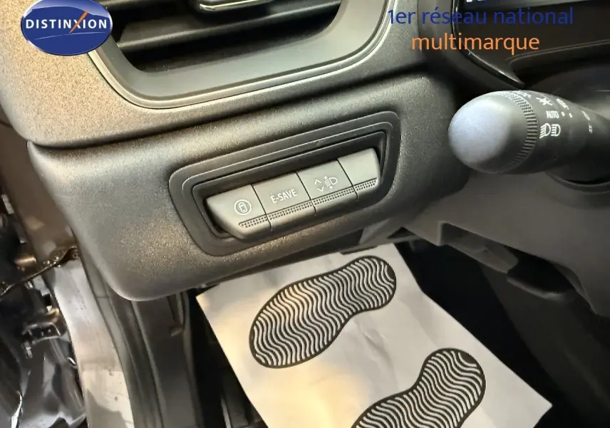 Vue intérieure côté conducteur du Renault Captur gris Cassiopée, montrant les commandes E-SAVE et réglage des phares.